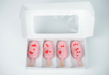 Heart-shaped treats in a box perfect for Valentine's Day celebration with love-themed decorations and a pastel color theme