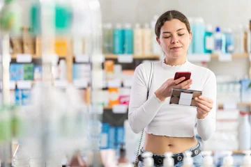 Fotobehang Muziek Young woman scans mobile barcode of makeup powder palette. Buying and paying for makeup products at the pharmacy  © JackF