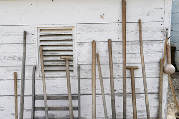 Old farm tools against a weathered barn