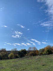 Blue sky with fluffy white clouds on a sunny day. Bright, peaceful natural background symbolizing freedom and tranquility.
