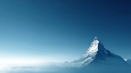Dramatic snowcovered mountain peak rising through mist against a clear blue sky with sharp jagged edges and vast background space