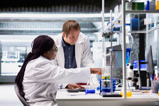 Laboratory staff work as a team on diagnostics and testing procedures. Scientist work combining molecular science, genetics research and biotechnology, future digital health solutions.