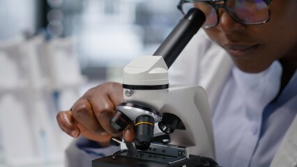Microscope close up of glass tray under the lens for cellular analysis, expert studying molecular...