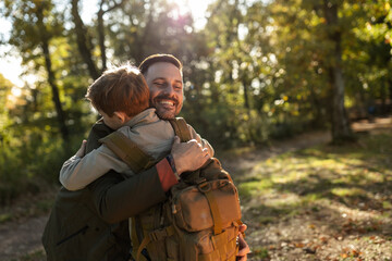 Man and son hugging in forest
