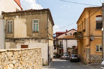 Old residential streets in Ohrid, North Macedonia, showcasing traditional Balkan architecture with tiled roofs, stone walls, and summer vegetation in historic lakefront town