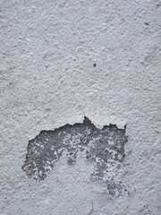A wall with a lot of dirt and grime on it. The wall is white and has a lot of cracks and holes