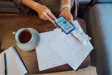Managing personal finances on smartphone. No face woman checking financial balance on smartphone...