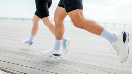 Fototapeta premium Two runners enjoying a morning jog along a seaside walking path