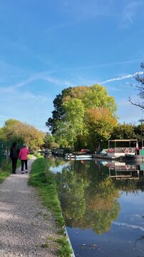 Odiham Hampshire England UK. 27.10.2025. Video.  Two women walking on towpath of the Basingstoke Canal at Odiham in Hampshire England UK.