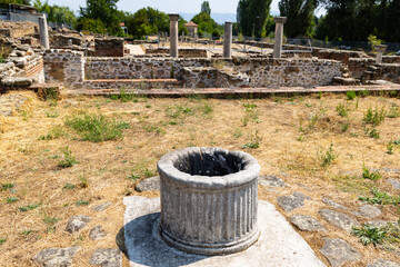 Scenic summer view of archaeological site of Heraclea Lyncestis near Bitola, North Macedonia, overlooking ruins of ancient layered stone walls, marble columns, and surrounding greenery