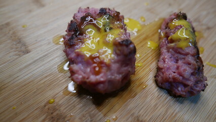 A close-up shot of a sausage covered in mustard and ketchup. Grilled sausage on the table. Sausage day.