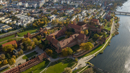 Obraz premium Aerial view of Malbork Castle along the Nogat River in Poland