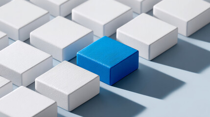 Obraz premium A blue block among white blocks on a light grey surface with shadows cast by the cubes