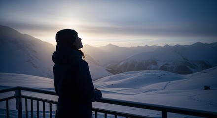 Silhouette of a lone traveler on a snowy balcony at blue hour facing distant peaks