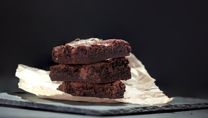A stack of delicious chocolate brownies on a dark background