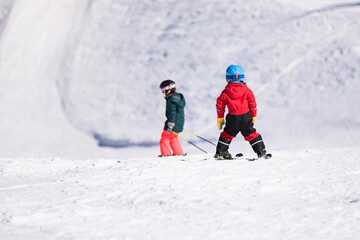 Children learning skiing on snowy mountain slope