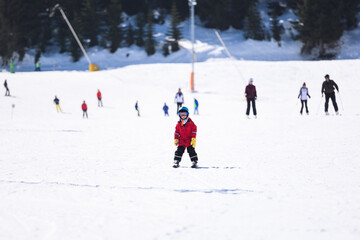 Young boy learning skiing on snowy mountain slope