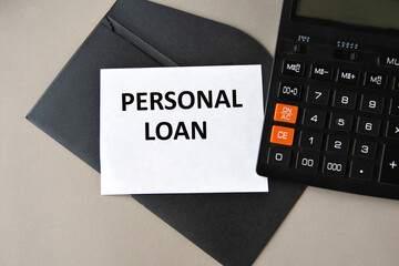 PERSONAL LOAN - words on white sheet on black envelope with calculator