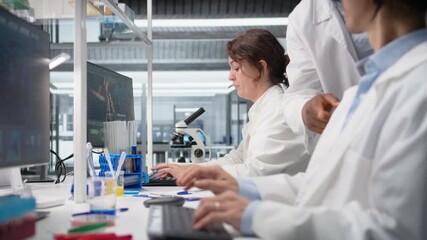 Nanotechnology researcher checking time, waiting to finish shift, processing patient data. Lab employee using PC to do genetic analysis diagnostics checking wrist watch clock, camera A - Powered by Adobe