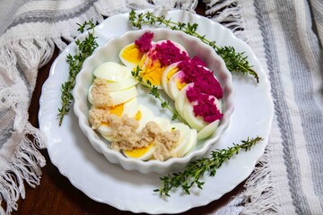 Hearty and rustic food, boiled egg with horseradish and decorated with sprigs of fresh thyme.