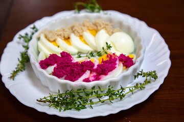 Hearty and rustic food, boiled egg with horseradish and decorated with sprigs of fresh thyme.