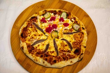 Exotic and original Brazilian pizza with two flavors, one with anchovies and the other with egg, horseradish, and cucumber pickles.