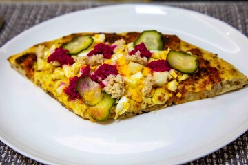 Exotic and original Brazilian pizza with two flavors, one with anchovies and the other with egg, horseradish, and cucumber pickles.