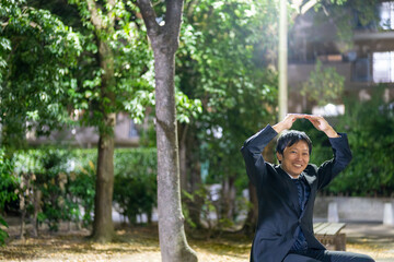 夜の公園でOKサインを示すサラリーマン