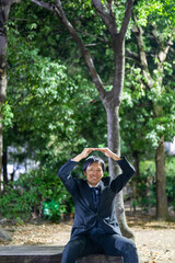 夜の公園でOKサインを示すサラリーマン