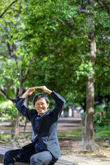 ベンチで丸ポーズ、合意を伝えるビジネスマン