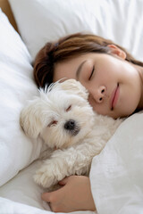 白い犬と女性が寄り添って眠る癒しのひととき
