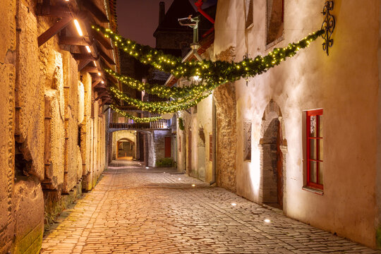 Christmas lights over medieval St Catherine's Passage at night in Tallinn, Estonia - Powered by Adobe