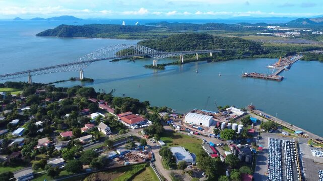 Bridge of the americas  aerial view close to the Panama Canal An expansive drone shot captures a significant infrastructure development underway along a lush, green coastline and a bustling port area