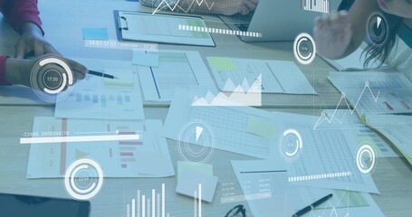Reviewing colleagues analyzing printed spreadsheets at conference table, with digital data overlays