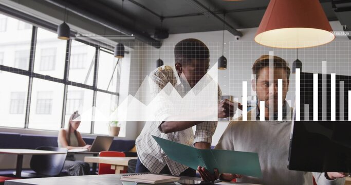 Leaning Black male and white male reviewing documents at modern office, with folder and monitor