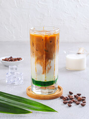 Iced Coffee with Milk and Green Syrup Layer – Refreshing Pandan Latte Beverage on Light Background. Iced Pandan Coffee Latte with Milk and Green Syrup – Summer Drink Concept
