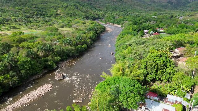 Aerial panorama of wide tropical river, Flowing water and surrounding forest, Sumapaz River in Tolemaida Colombia. High quality 4k footage