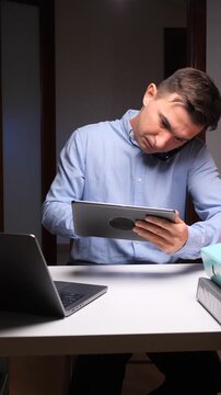 vertical video Stressed man working overtime multitasking with multiple devices