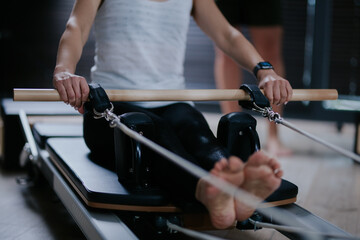 Spectators observe a reformer pilates class focusing on core strength and flexibility with instructors guiding participants through various exercises in a modern studio