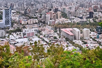 Fototapeta premium Santiago, Chile. 2020. A urban landscape from San Cristobal Hill showing public streets of Las Condes and Vitacura neighborhoods, and the Andes Cordillera's mountains in the background.