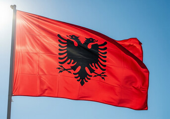 Albanian Flag Waving in the Wind with Sunlight Against a Blue Sky, National Symbol, Albania.