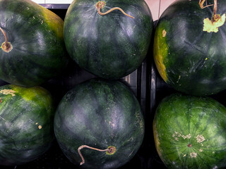 Juicy watermelons stacked fresh from the farm, ready for summer picnics and healthy treats, a...