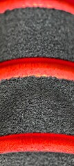 Textured dark material with red bands