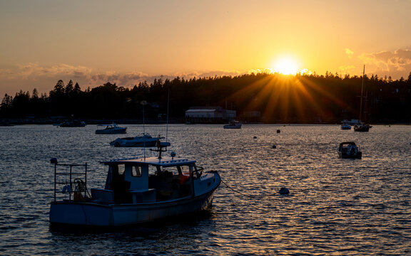 An lake with boats under sunset with sunburst, sunstars	 - Powered by Adobe