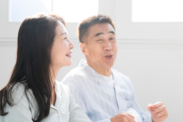 起きてベッドの上で会話をする夫婦