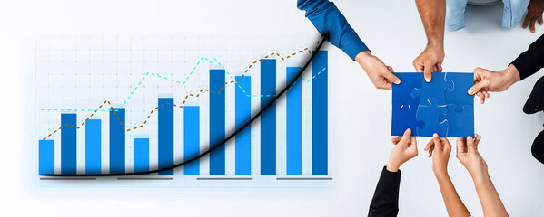 A group of professionals engages in teamwork, using graphs and puzzle pieces to symbolize strategic...