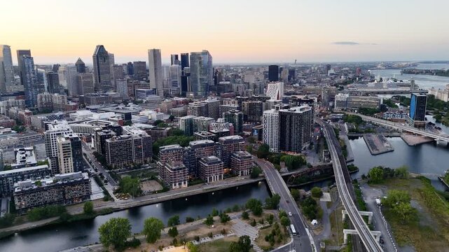 Aerial view of modern waterfront district with high-rise buildings and riverside paths, Montreal twilight skyline. g.