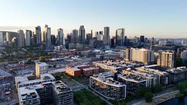 Aerial view of modern waterfront district with high-rise buildings and riverside paths, Montreal twilight skyline. g.