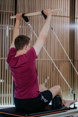 Engaging in reformer pilates workout at fitness studio focusing on strength and flexibility...