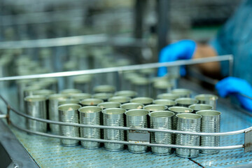 Inspector checking automated machinery in food production facility Focus on quality control safety and workflow efficiency. Worker overseeing food packaging machinery in a modern manufacturing plant.
